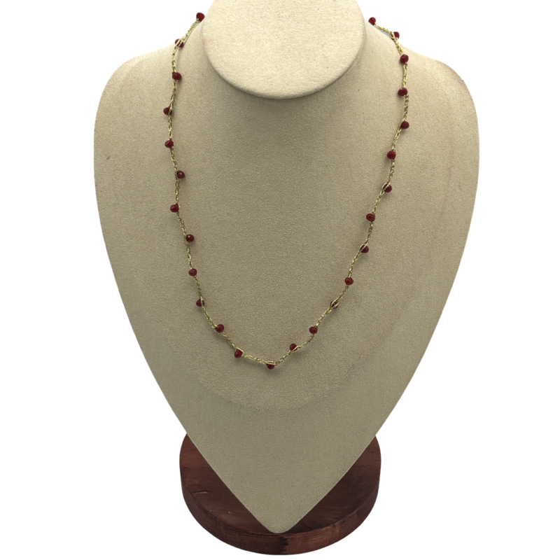 Collana artigianale dorata con piccole perline rosso bordeaux distribuite lungo la catena, gioiello elegante e minimal.