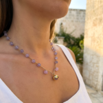Un design essenziale e sofisticato incontra le sfumature lavanda della pasta di vetro, creando una collana luminosa e femminile dal carattere autenticamente mediterraneo.