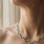 Dettaglio delle perle verde acqua della collana Verdeacqua Monochrome indossata su collo, eleganza minimal e luce mediterranea