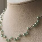 Dettaglio delle perle verde acqua della collana Verdeacqua Monochrome indossata su collo, eleganza minimal e luce mediterranea