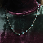 Collana Verdeacqua Monochrome indossata su collo con maglione, perle verde acqua luminose, eleganza minimal e raffinata