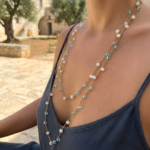 Collana lunga dorata con pietre bianche e azzurre in masseria pugliese