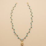 Collana Pumo Mediterraneo – gioiello artigianale ispirato alla tradizione pugliese, con dettagli che richiamano il simbolo del pumo e le tonalità del mare del Sud Italia. Un accessorio luminoso e raffinato, perfetto per chi ama lo stile mediterraneo autentico e senza tempo.